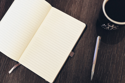 Unternehmensberatung auf Papier Ein aufgeschlagenes Buch, daneben eine Tasse